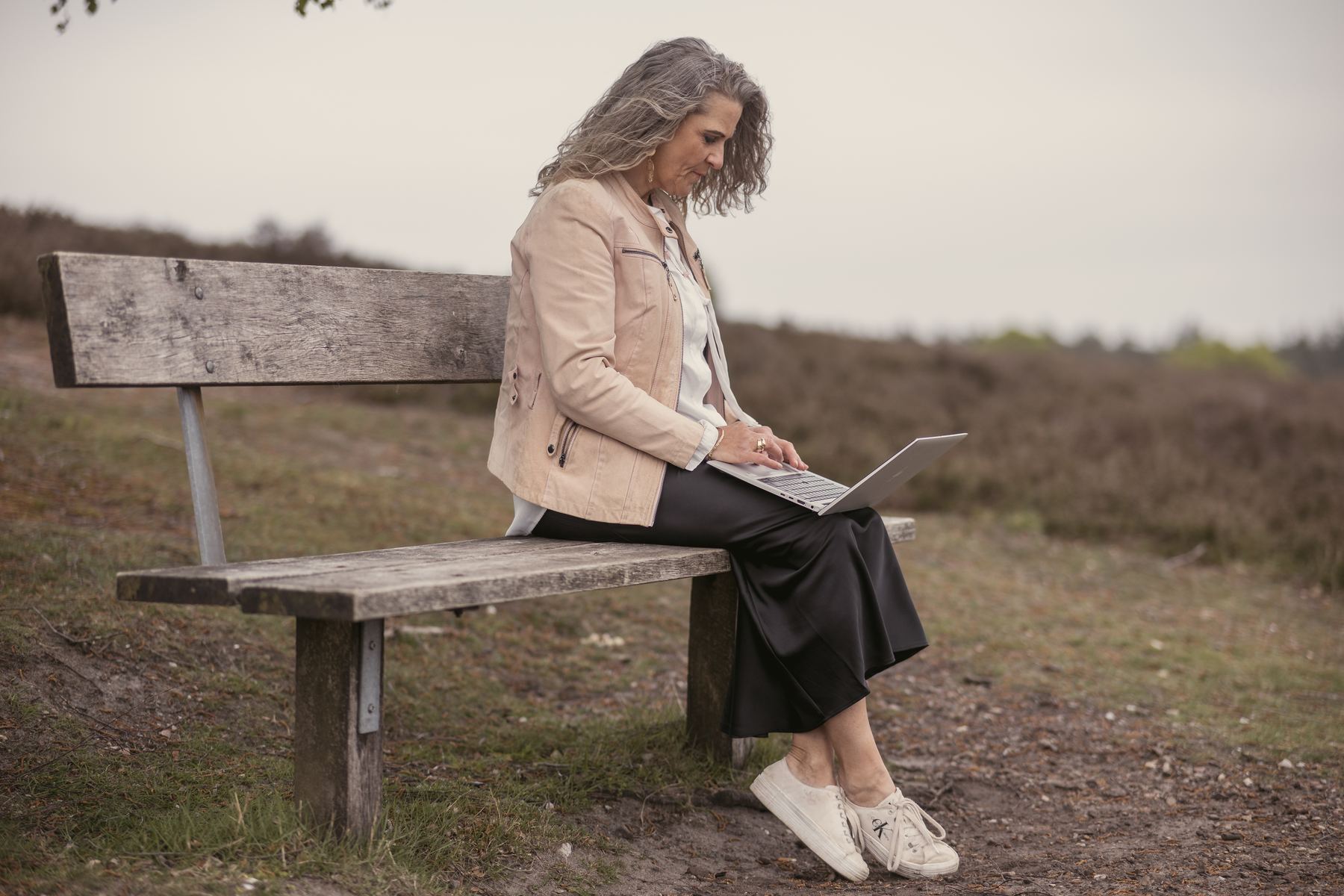 Britta Selina arbeitet im Freien am Laptop – flexibles Online-Coaching